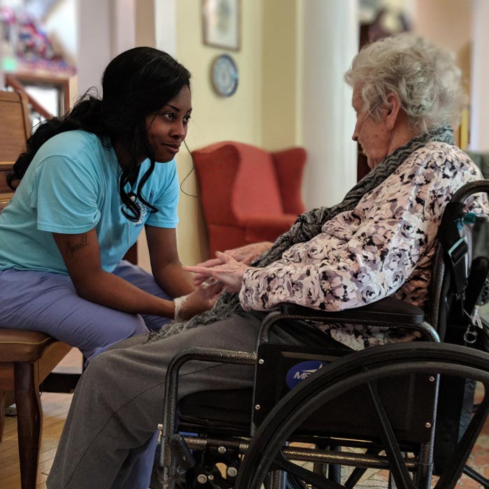 assisted living caretaker with woman in wheelchair
