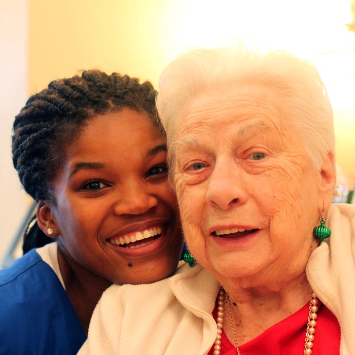 resident and aide smiling